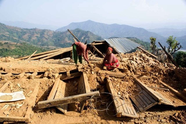 A woman and her mother-in-law collecting the remaining of their house in Sindhupalchowk district of Central Nepal